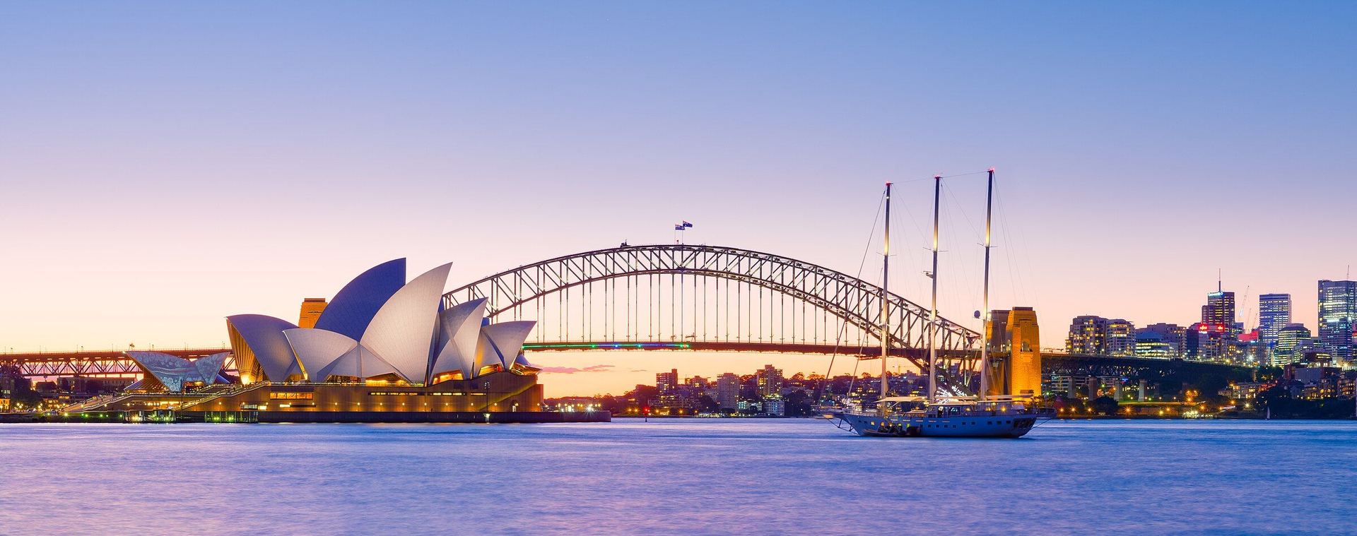 Sydney Harbour at dusk: the Opera House and the Harbour Bridge.